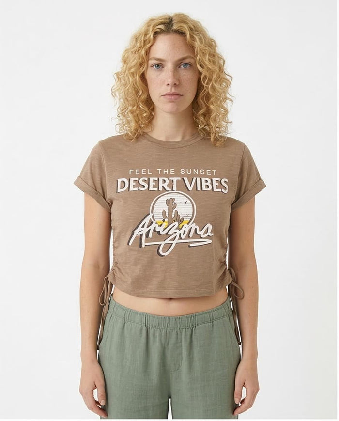 Woman wearing a brown t-shirt with 'Desert Vibes Arizona' text and graphics on a white background