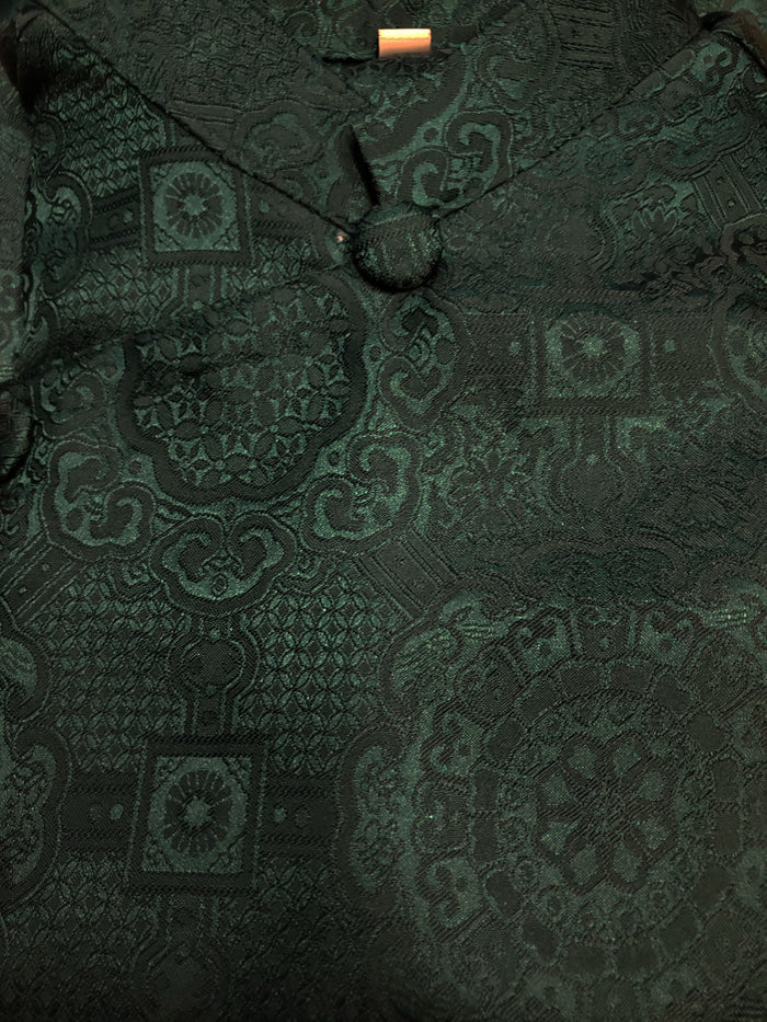 Dark green patterned fabric with a close-up view