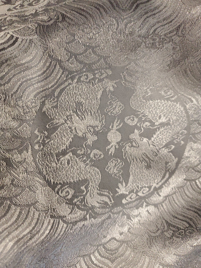 Decorative fabric with intricate dragon pattern on a textured background
