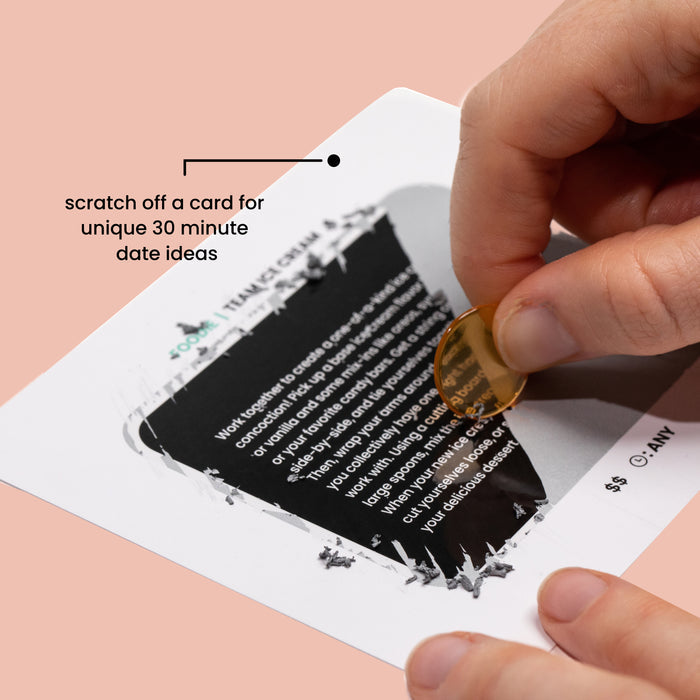 Hand scratchong a Mini Dates card, ready to reveal a quick and fun date night idea.