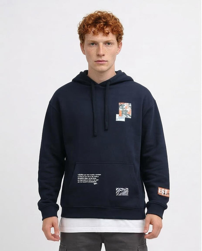 Man wearing a navy blue hoodie with a colorful patch on a white background