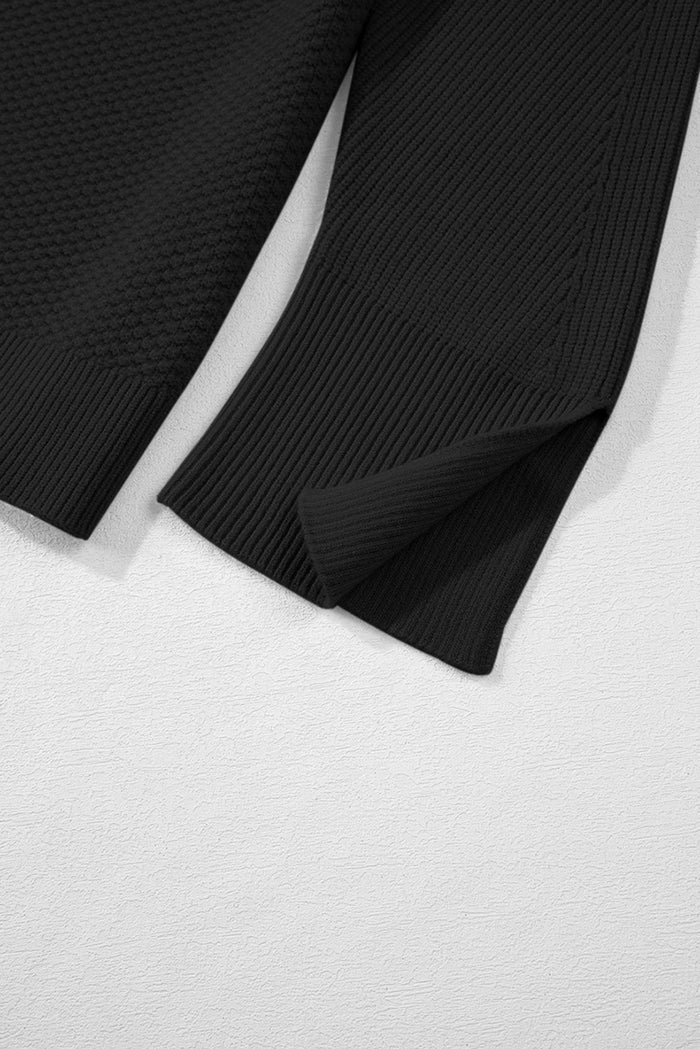 Pull ample noir en tricot texturé uni, manchette fendue*