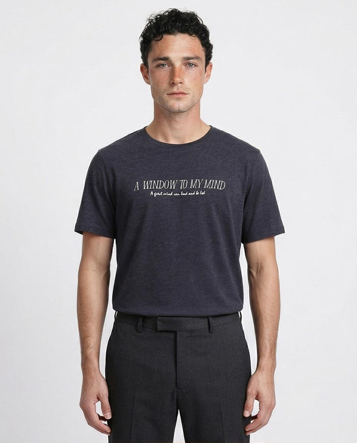 Man wearing a dark gray t-shirt with text on a white background