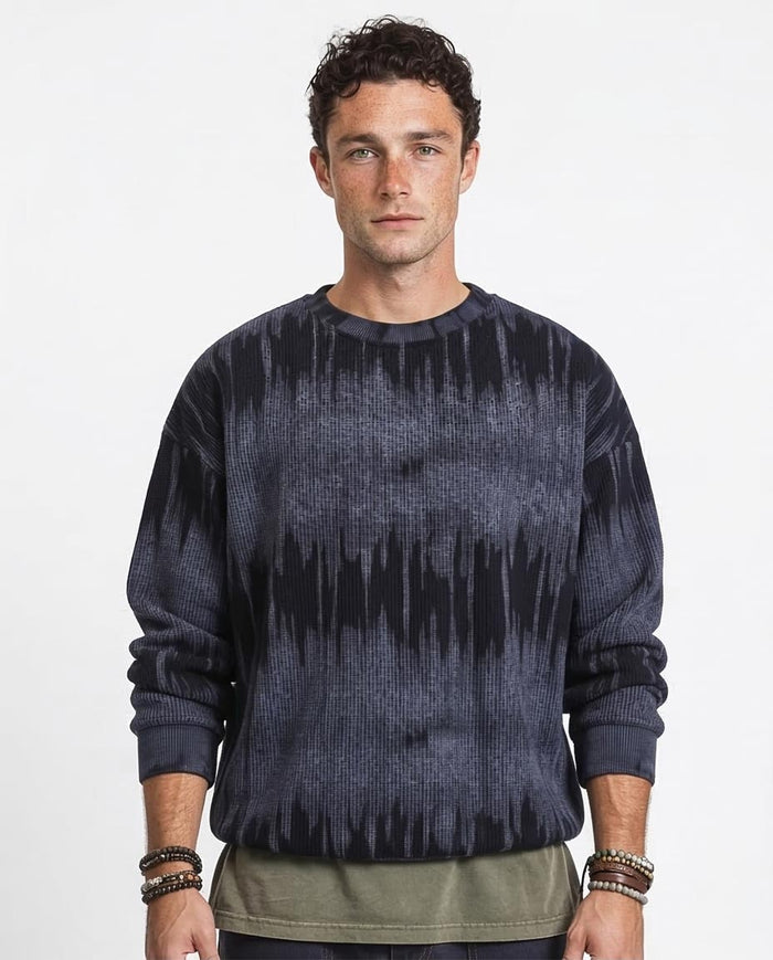 Man wearing a dark blue tie-dye sweater on a white background