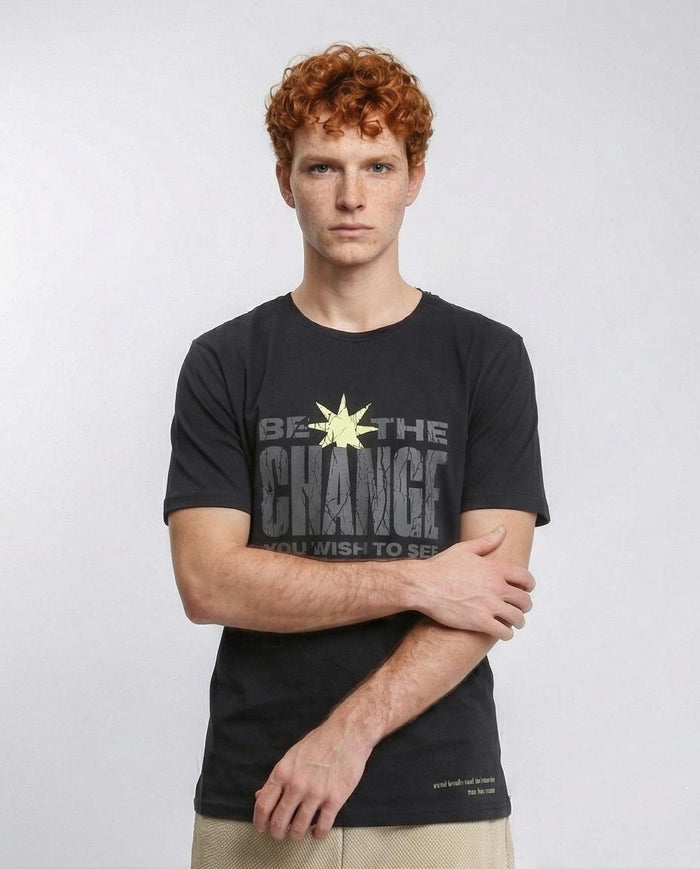 Man wearing a black t-shirt with 'Be the Change' text on a white background