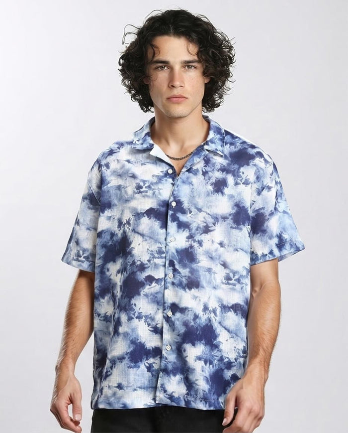 Man wearing a blue and white tie-dye shirt on a plain background