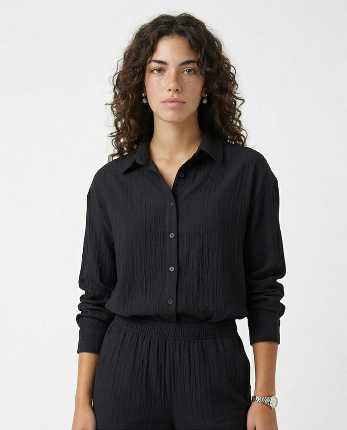 Woman wearing a black shirt and pants on a white background