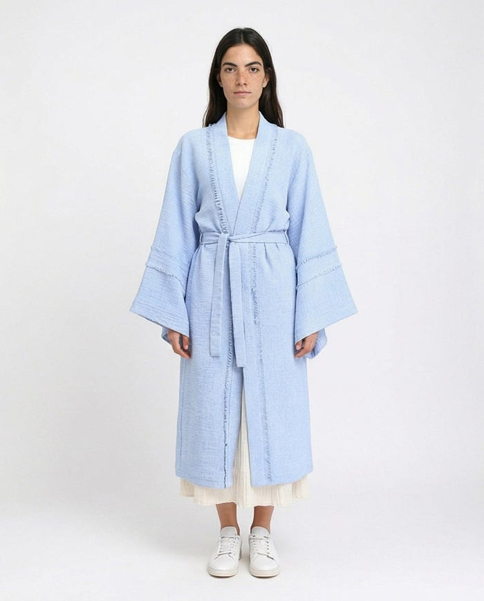 Woman wearing a light blue robe on a white background