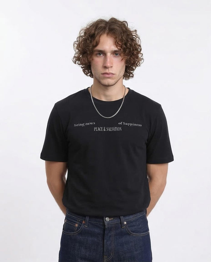 Person wearing a black t-shirt with text on a white background