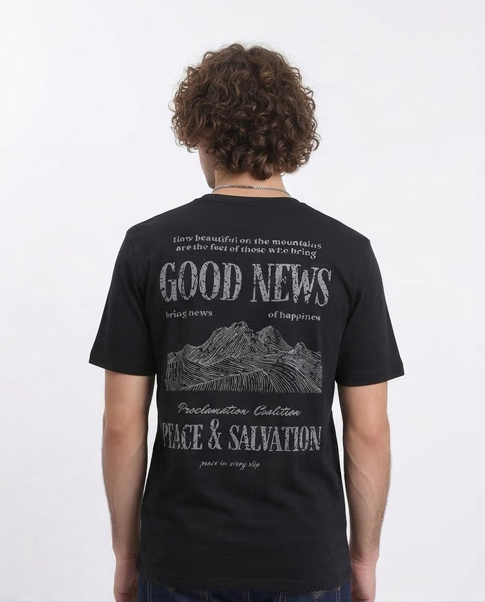 Person wearing a black t-shirt with text and mountain graphic on the back, on a white background