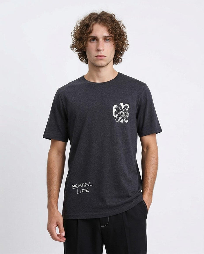 Man wearing a black t-shirt with a white graphic design on a plain background