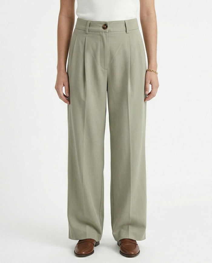 Woman wearing light green wide-leg pants on a white background