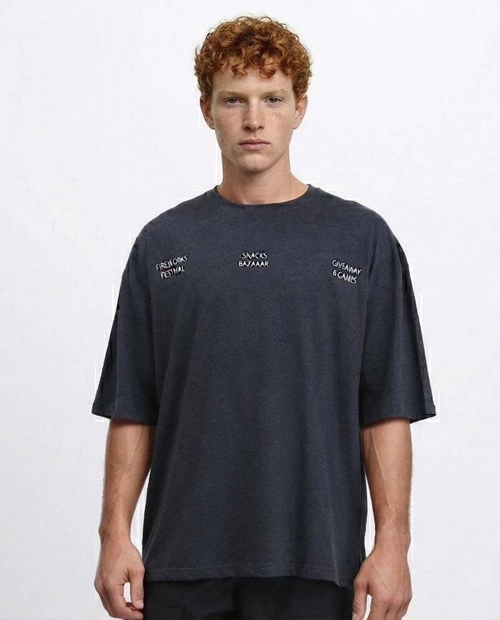 Man wearing a navy t-shirt with brand logos on a light gray background