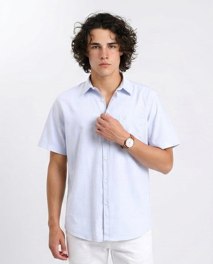 Man wearing a light blue short-sleeve shirt on a white background