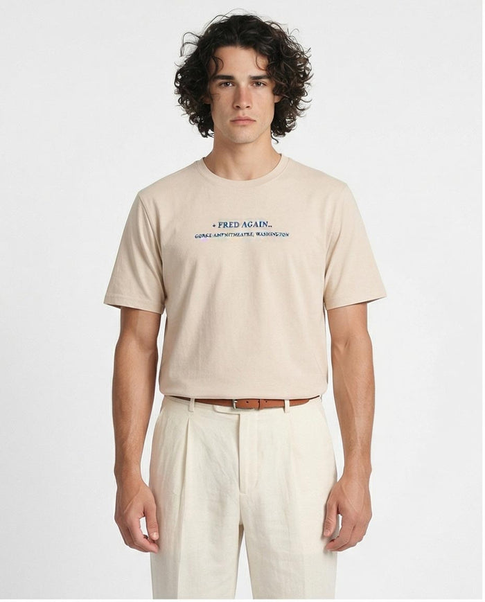 Man wearing a beige t-shirt with text on a white background
