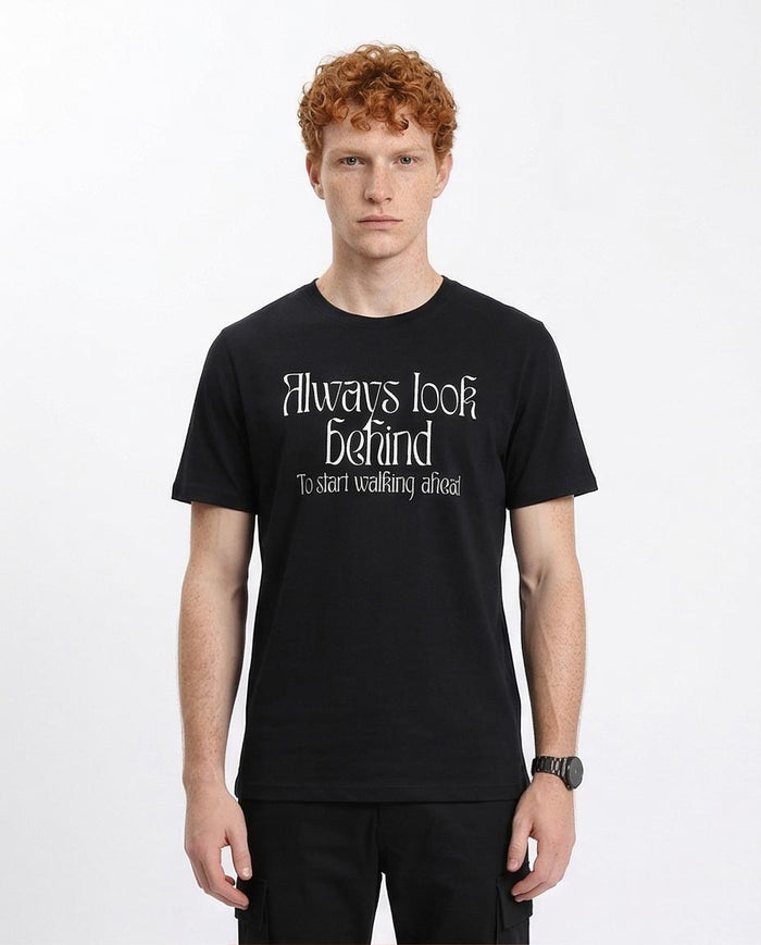 Man wearing a black t-shirt with text on a white background