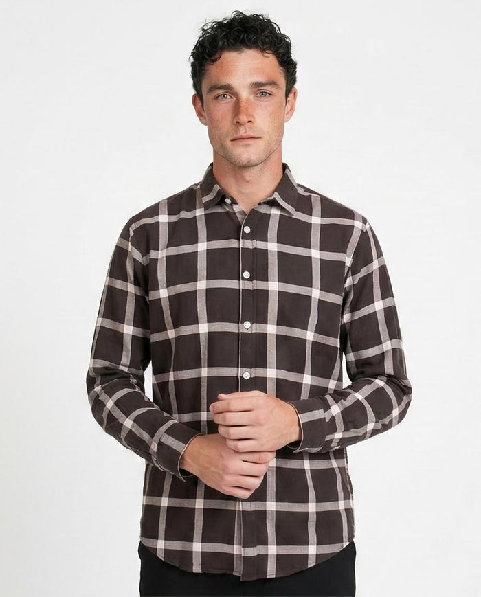 Man wearing a brown and white checkered shirt on a white background