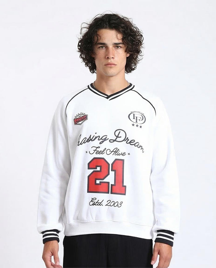Person wearing a white sweatshirt with text and numbers on a plain background
