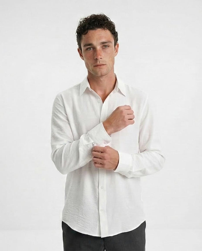 Man wearing a white dress shirt against a plain background