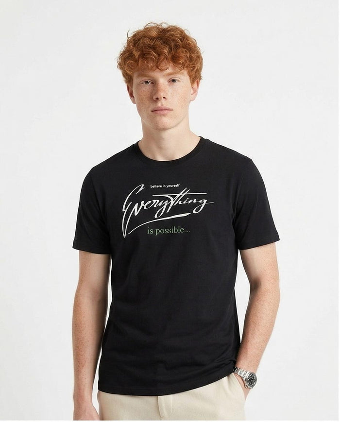 Man wearing a black t-shirt with 'Everything is possible' text on a white background