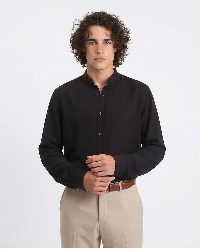 Man wearing a black shirt and beige pants on a white background