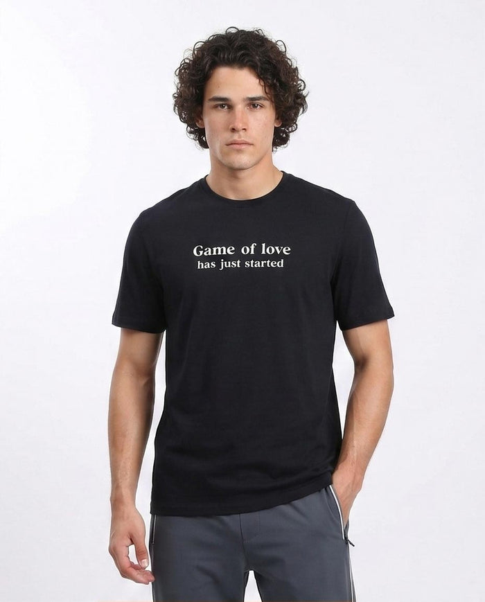 Man wearing a black t-shirt with 'Game of love has just started' text on a white background