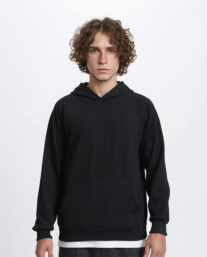 Person wearing a black hoodie on a white background