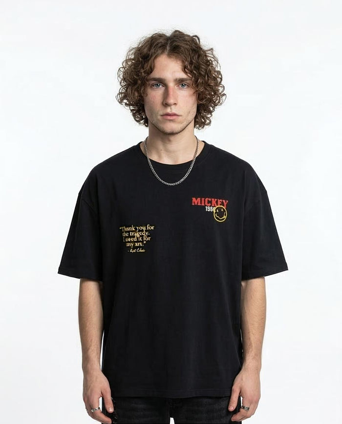 Person wearing a black t-shirt with text and logo on a white background