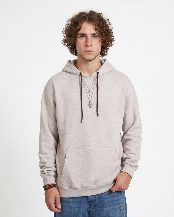 Man wearing a gray hoodie and blue jeans on a white background