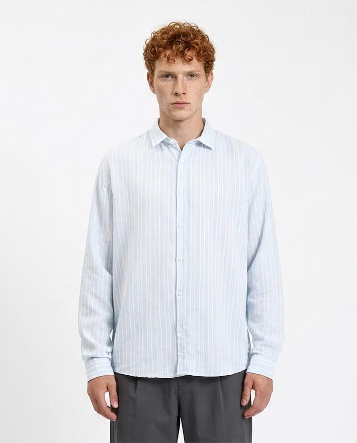 Man wearing a light blue striped shirt against a white background