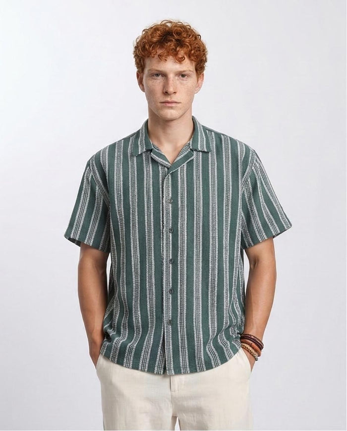 Man wearing a green and white striped shirt against a plain background