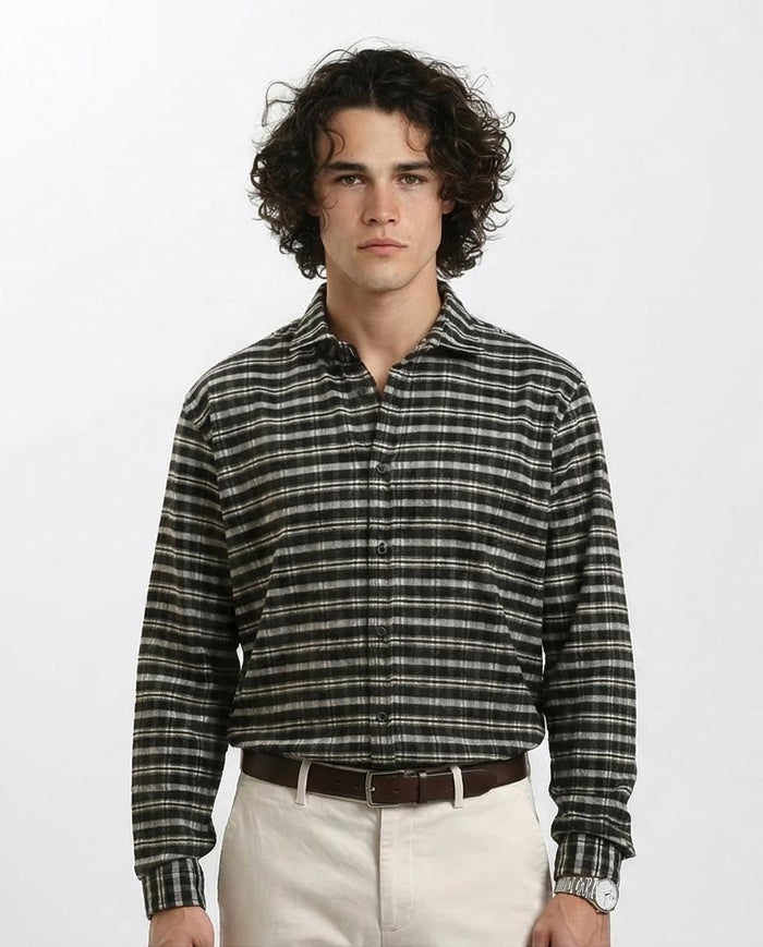 Man wearing a plaid shirt and beige pants on a white background