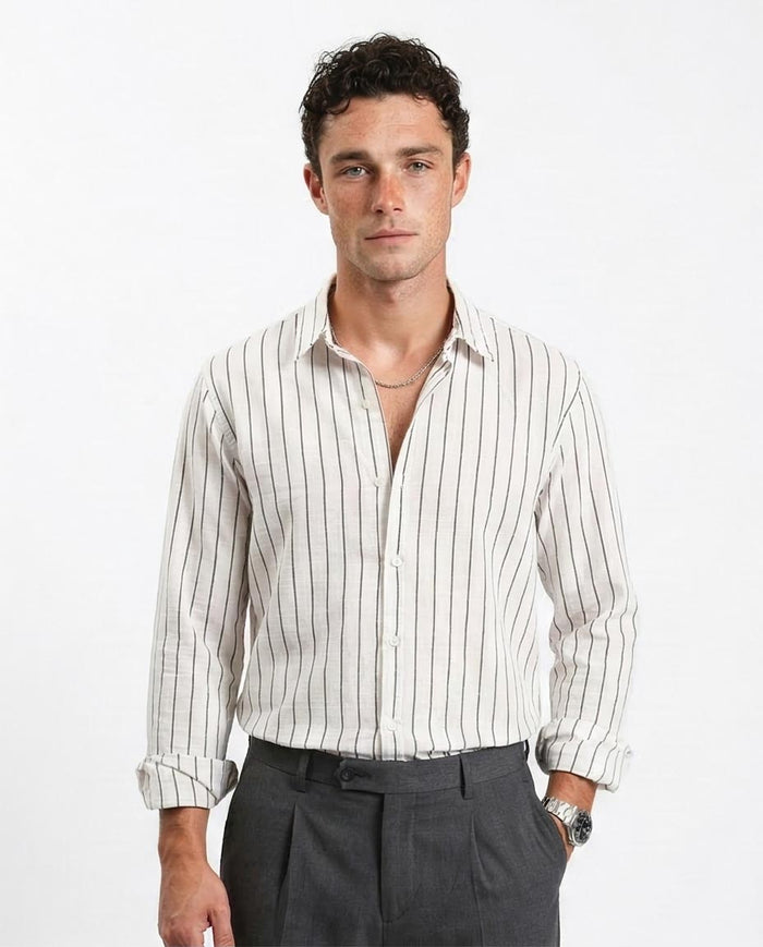Man wearing a white striped shirt and dark pants on a white background
