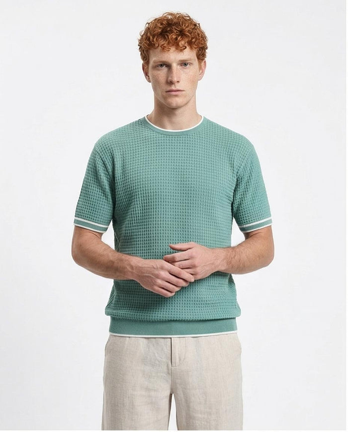Man wearing a green checkered shirt with white trim on a white background