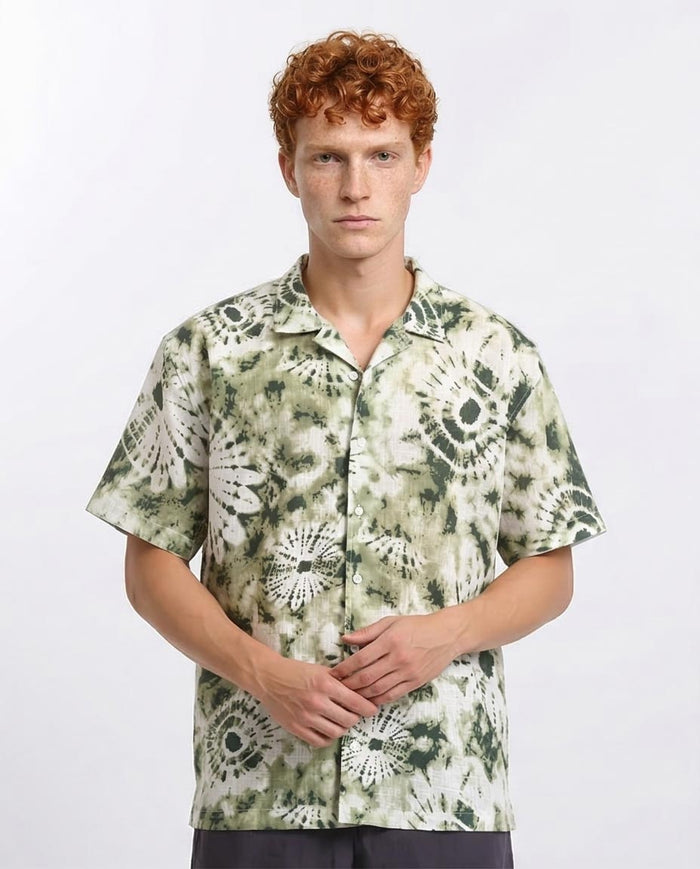 Man wearing a patterned shirt on a white background