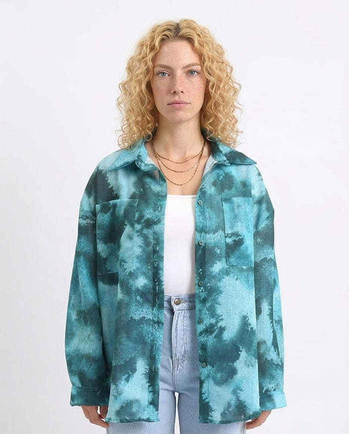 Woman wearing a teal tie-dye jacket on a white background