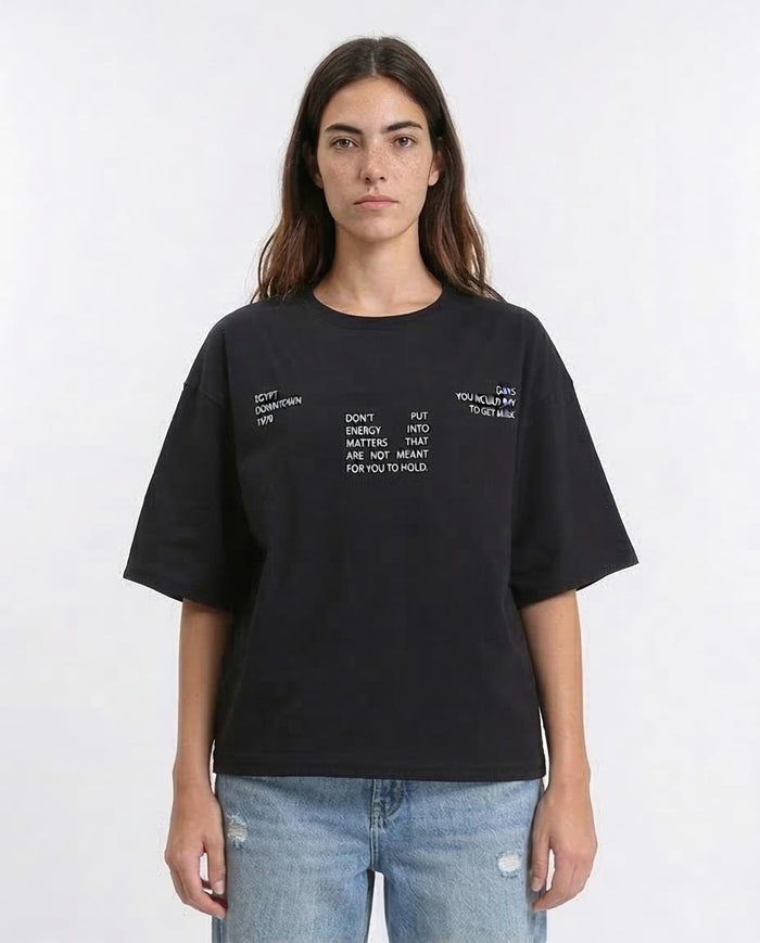 Woman wearing a black t-shirt with text on a white background