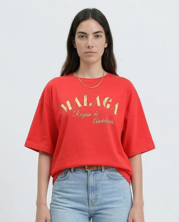 Woman wearing a red t-shirt with 'MALAGA' text on a plain background