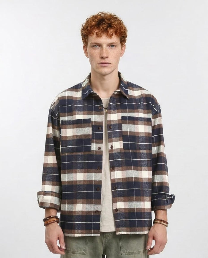 Man wearing a plaid shirt on a plain background