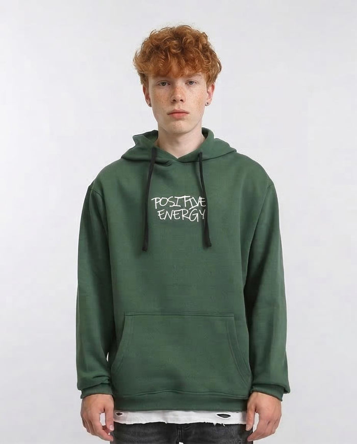 Person wearing a green hoodie with 'Positive Energy' text on a white background