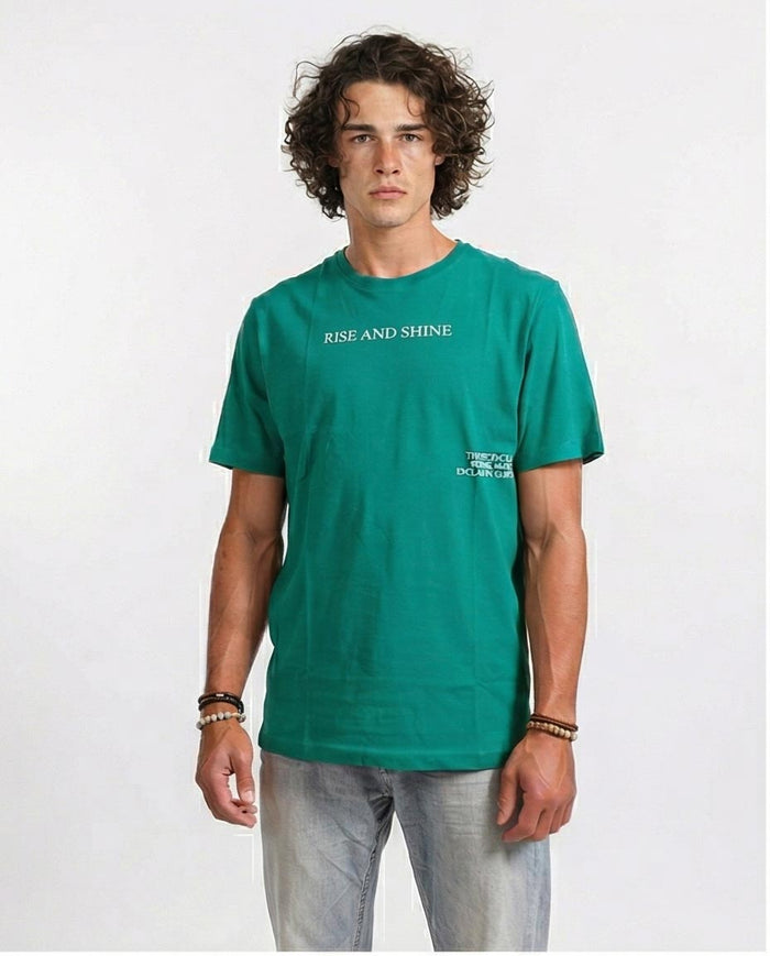 Man wearing a green t-shirt with 'RISE AND SHINE' text on a white background