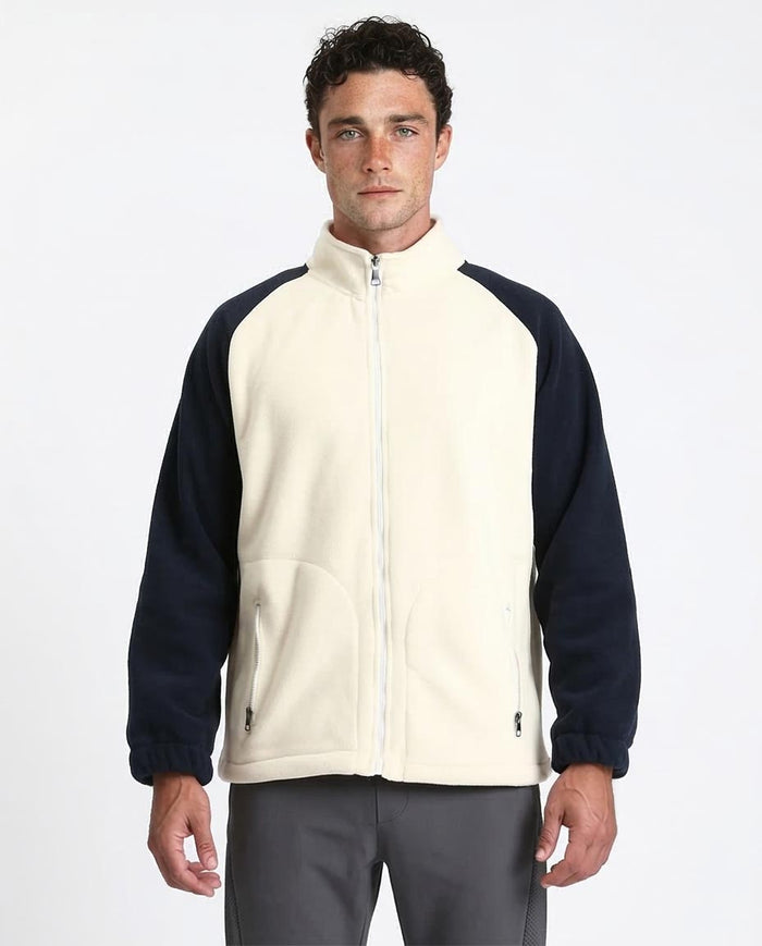 Man wearing a two-tone fleece jacket with navy sleeves and a cream body on a white background