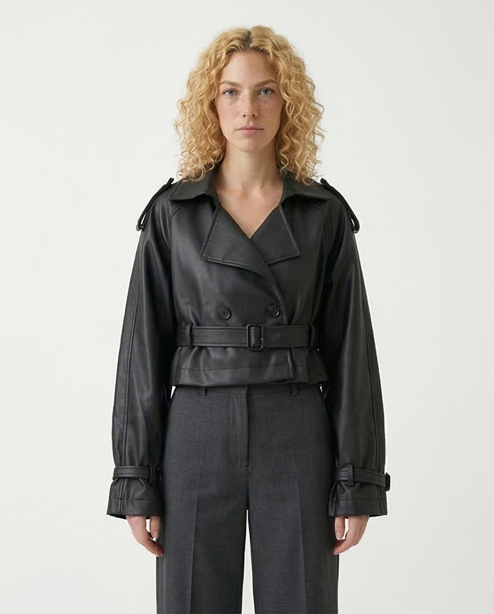 Woman wearing a black trench coat on a white background