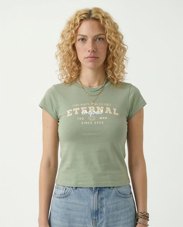 Woman wearing a green t-shirt with text and blue jeans on a white background
