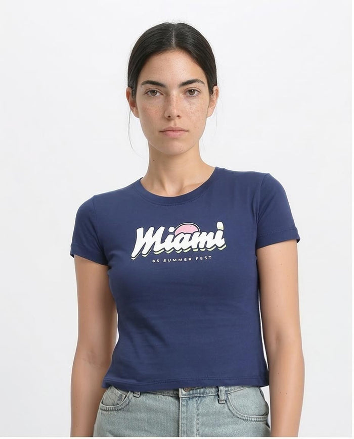 Person wearing a navy blue t-shirt with 'Miami' printed on it against a white background
