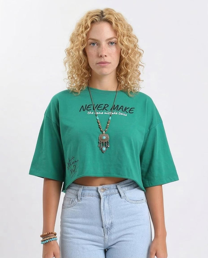 Woman wearing a green t-shirt with text and light blue jeans on a white background
