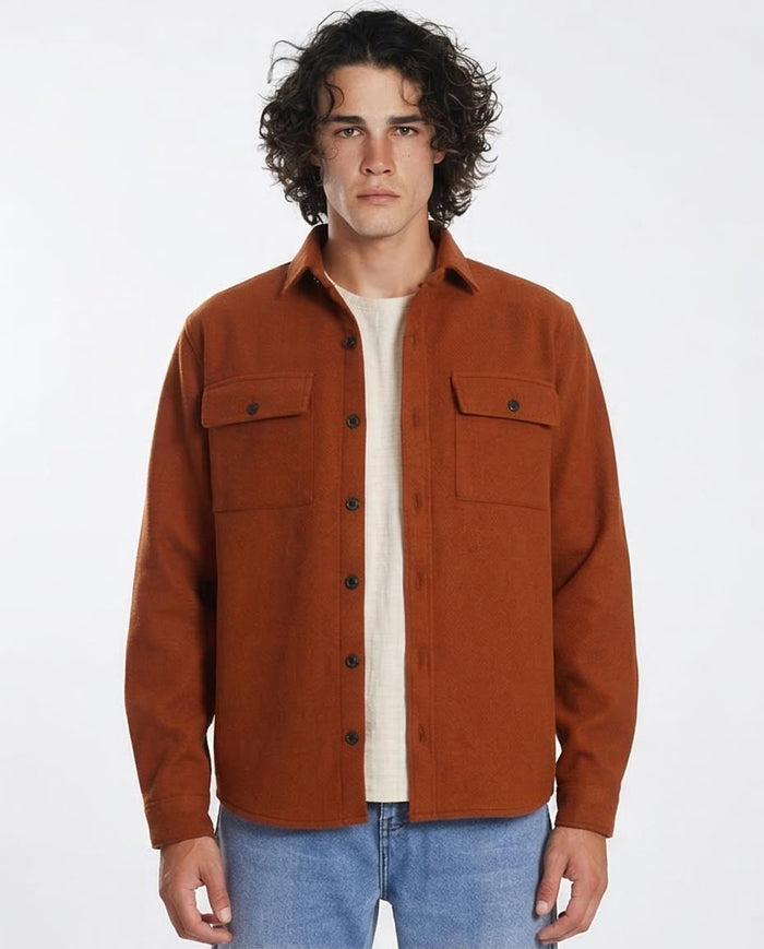 Man wearing a brown jacket over a white shirt on a white background